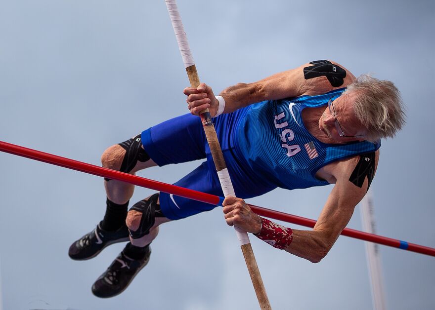  grey haired man pole vaulting