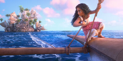 Moana crouches down while sailing her sail boat towards a small island covered in palm trees.