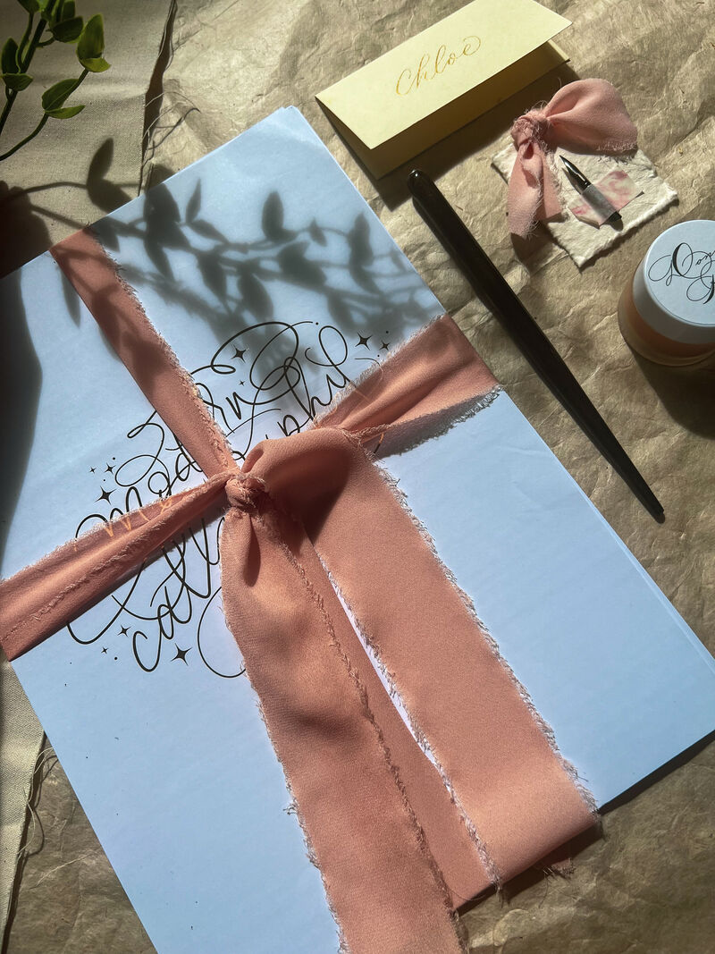 Selection of stationer featuring calligraphy and ties with pink bows