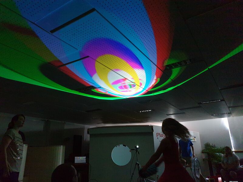 Children playing under colourful lights projected onto the ceiling of Create Space