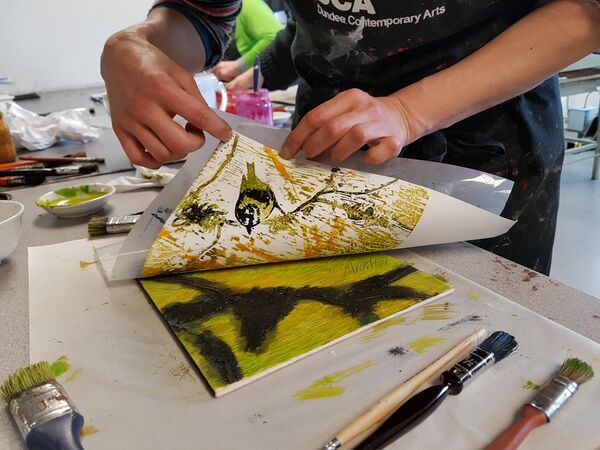 Person revealing a Japanese Woodblock print of birds