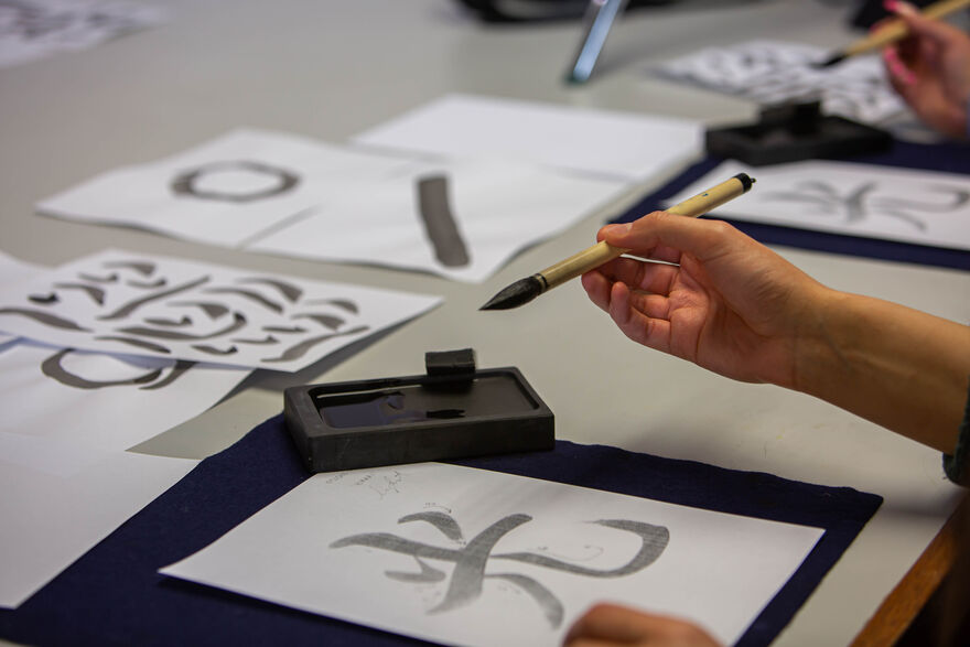 Someone doing Japanese Brush Calligraphy in DCA Print Studio