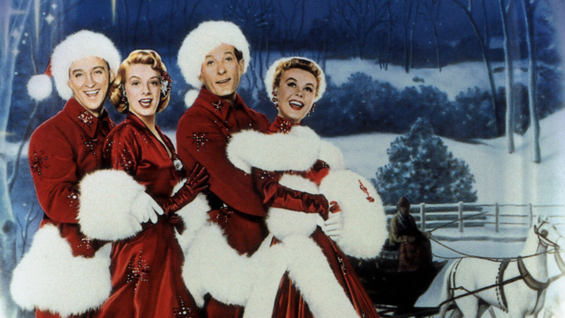 4 people do the conga and sing. They are all wearing red clothes with white fluffy trims. It is snowing in the background.