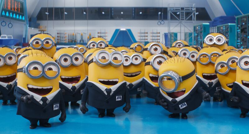 A group of smiling Minions, which are little yellow creatures wearing suits. T